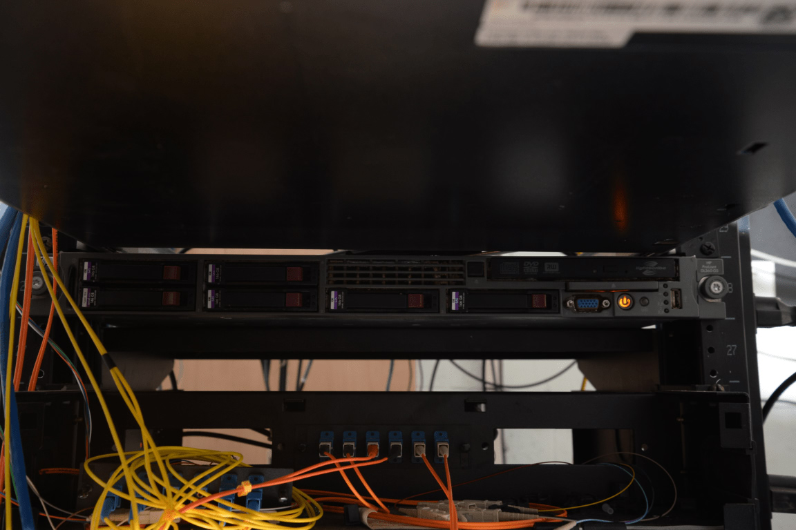 EFTA00002518 - Server rack with multiple hard drives and network cables connected in a data center environment.jpg